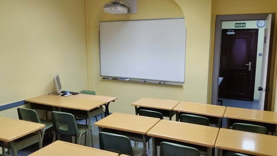 Aula con pizarra y proyector en Academia Minas